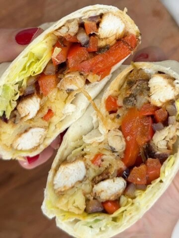 Someone holding a chicken fajita wrap.
