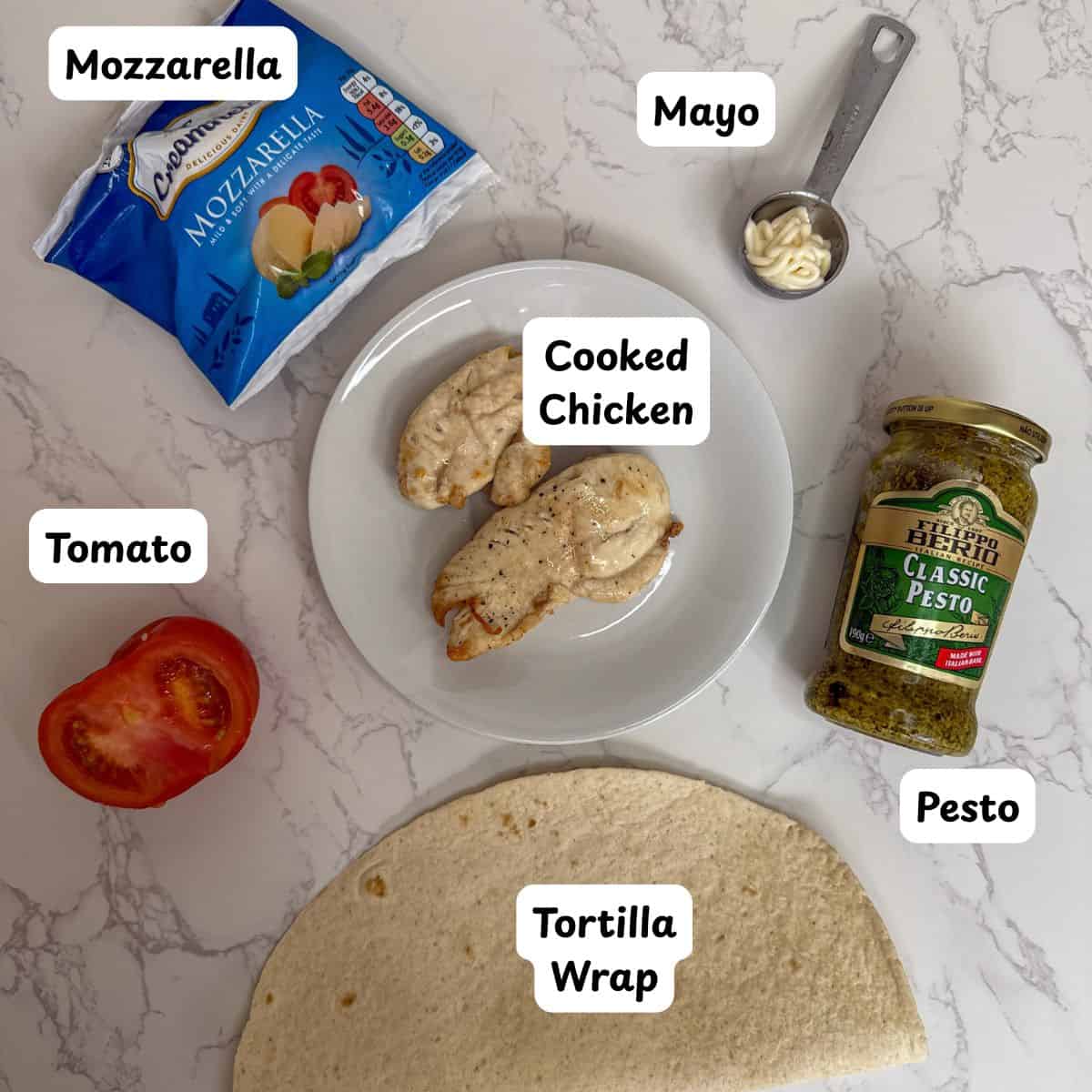 Ingredients laid out to make chicken mozzarella and pesto wrap.