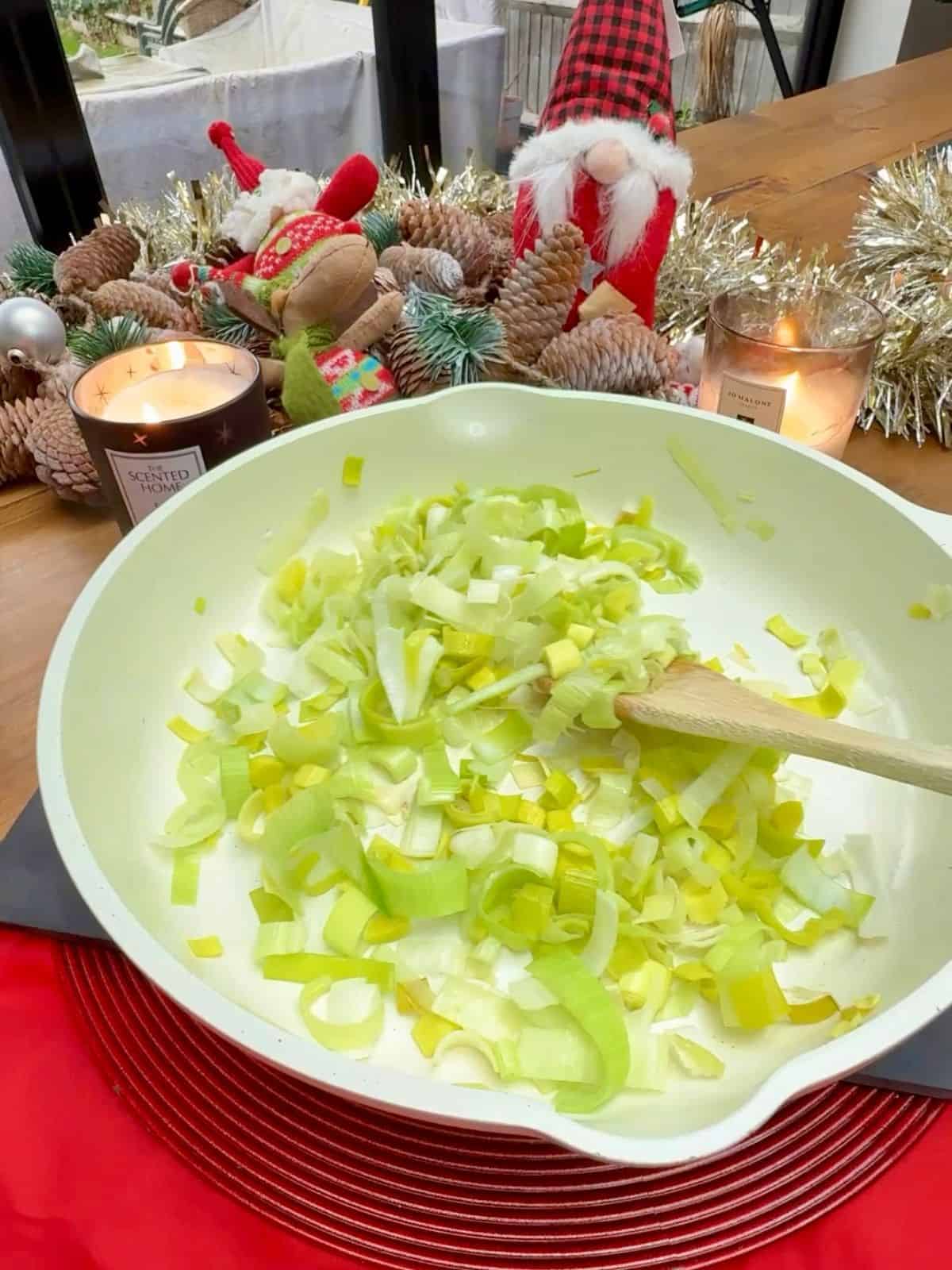 Sliced leeks being fried in a pan.