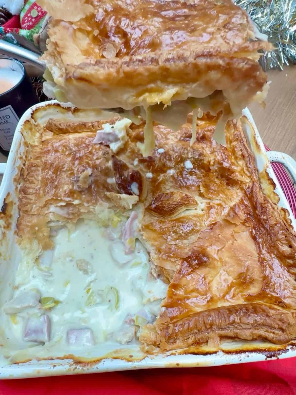 a portion of turkey pie being lifted from a dish.