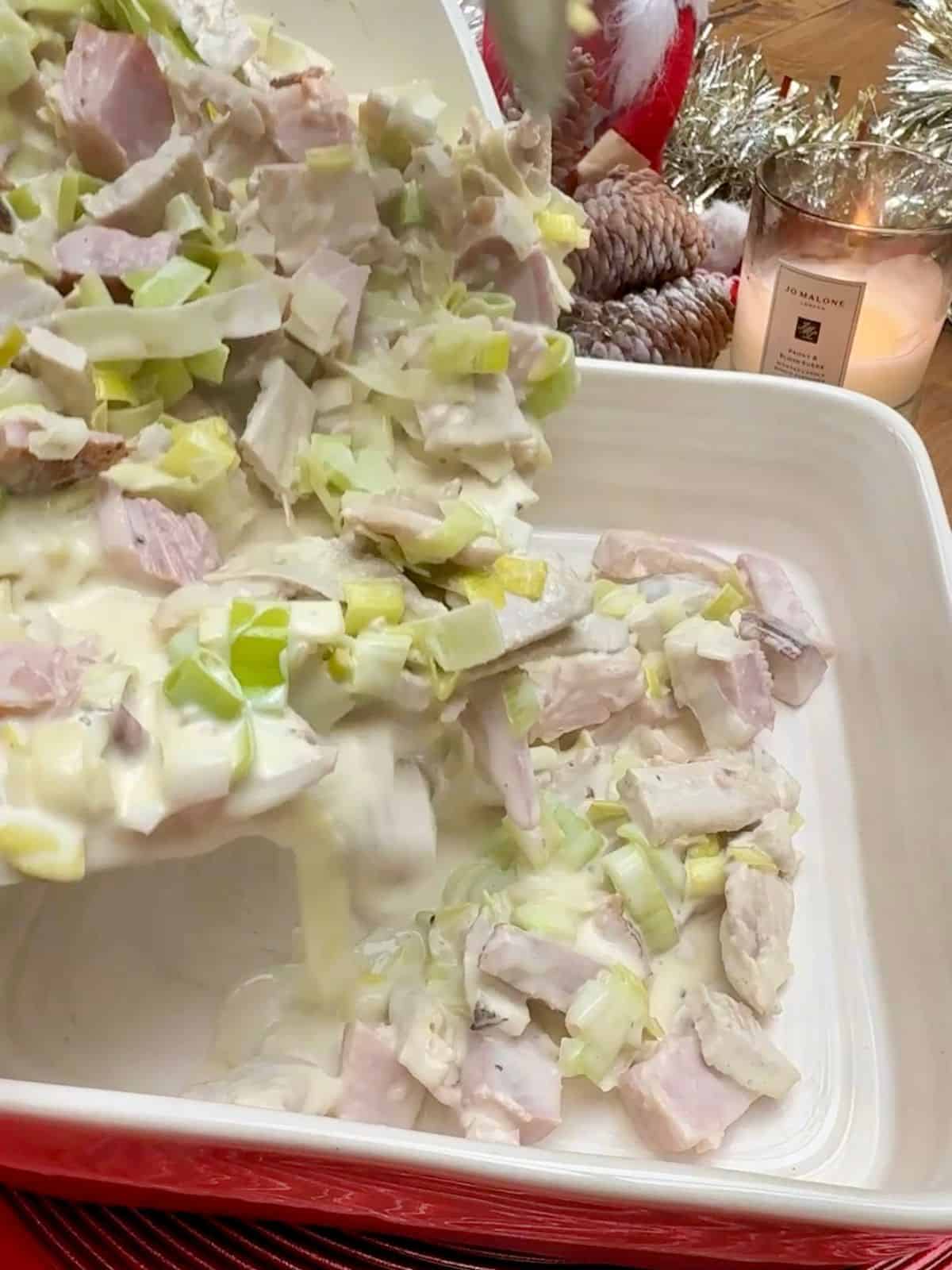 Turkey & ham pie filling being poured into a dish.
