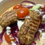 Lamb kofta kebab with tomatoes and red cabbage.