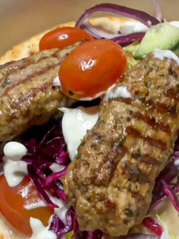 Lamb kofta kebab with tomatoes and red cabbage.