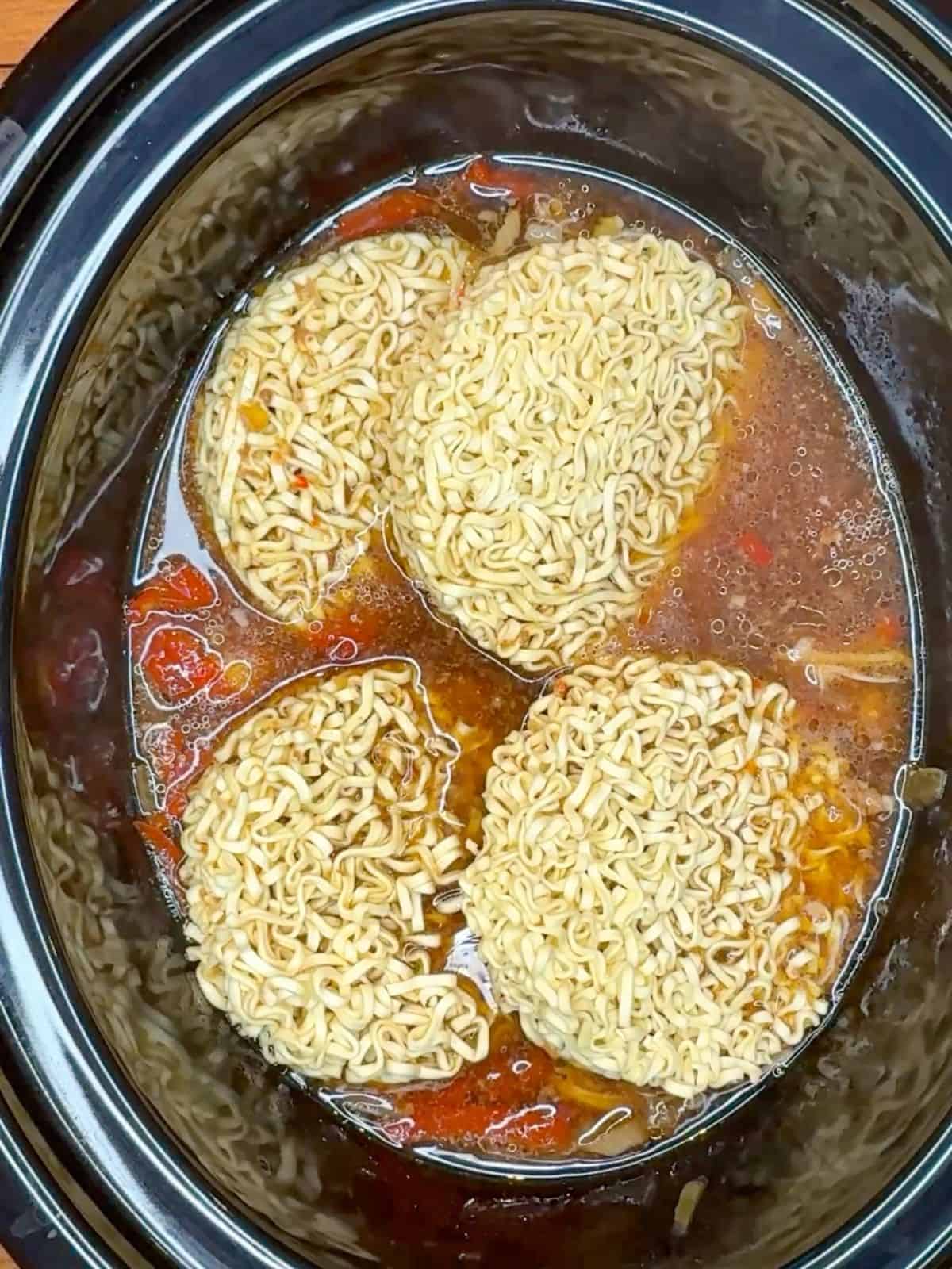noodles in a broth in a slow cooker.