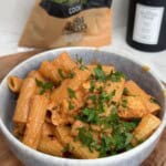 Chicken and halloumi pasta in a bowl garnished with parsley.