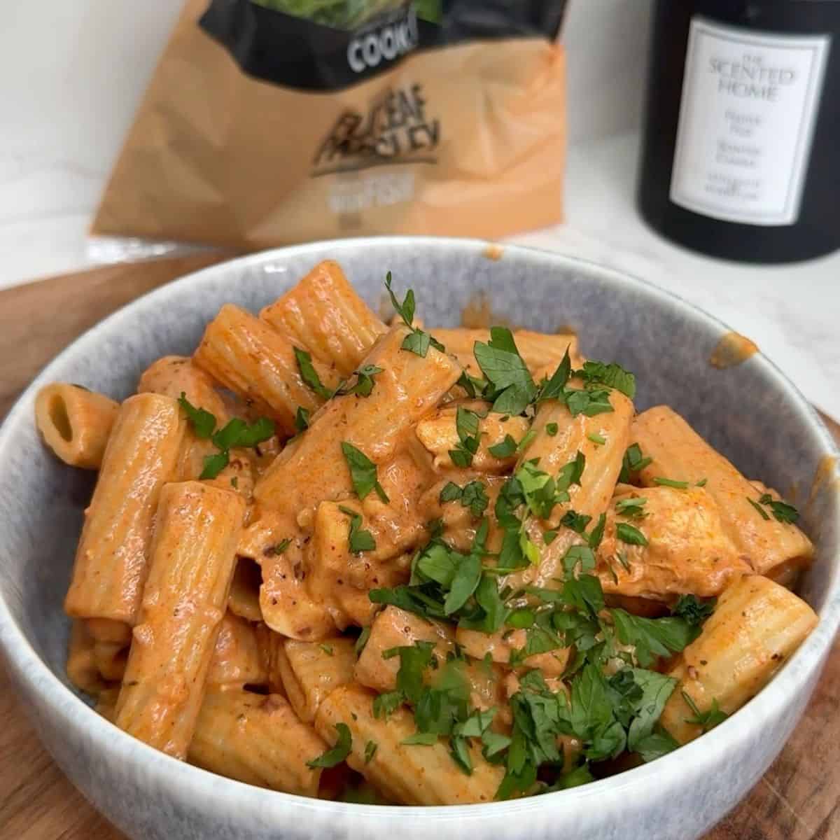 Chicken and halloumi pasta in a bowl garnished with parsley.