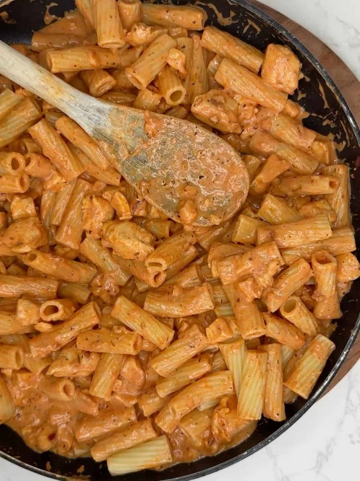 Chicken and halloumi pasta in a frying pan.