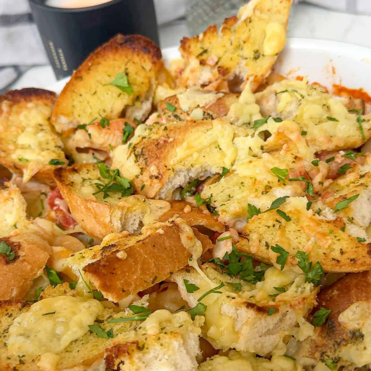 Garlic bread with cheese topped pasta bake.