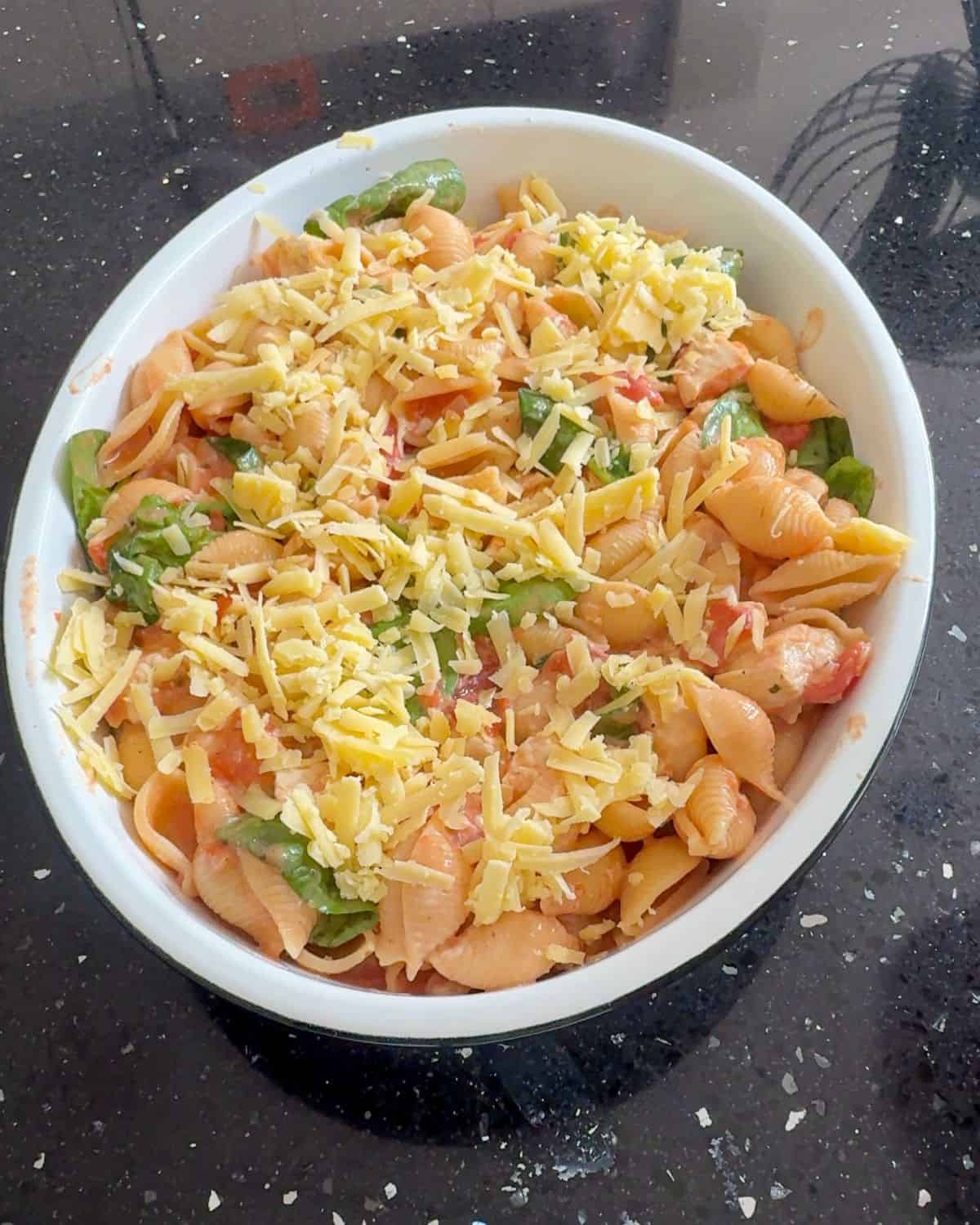 Pasta bake in a bowl topped with cheese.
