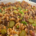 Cheeseburger pasta topped with gherkins and burger sauce.